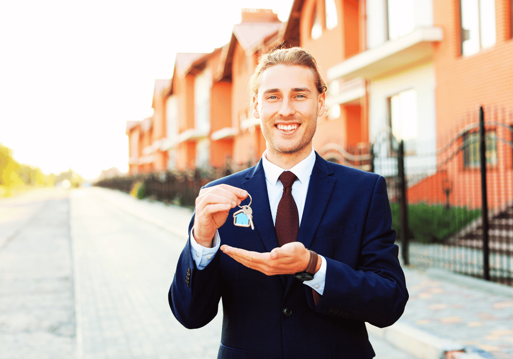 Asesor inmobiliario mostrando las llaves de tu nuevo hogar.